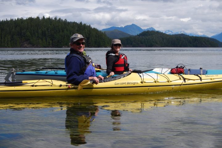 a group of people rowing a boat in the water