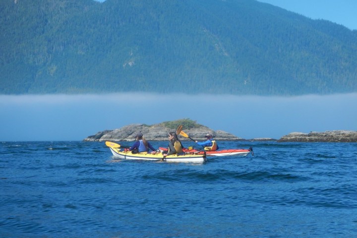 a small boat in a body of water with a mountain in the background